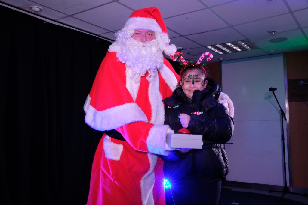 Santa and Christmas Bauble winner Lily turning on the Christmas Lights.